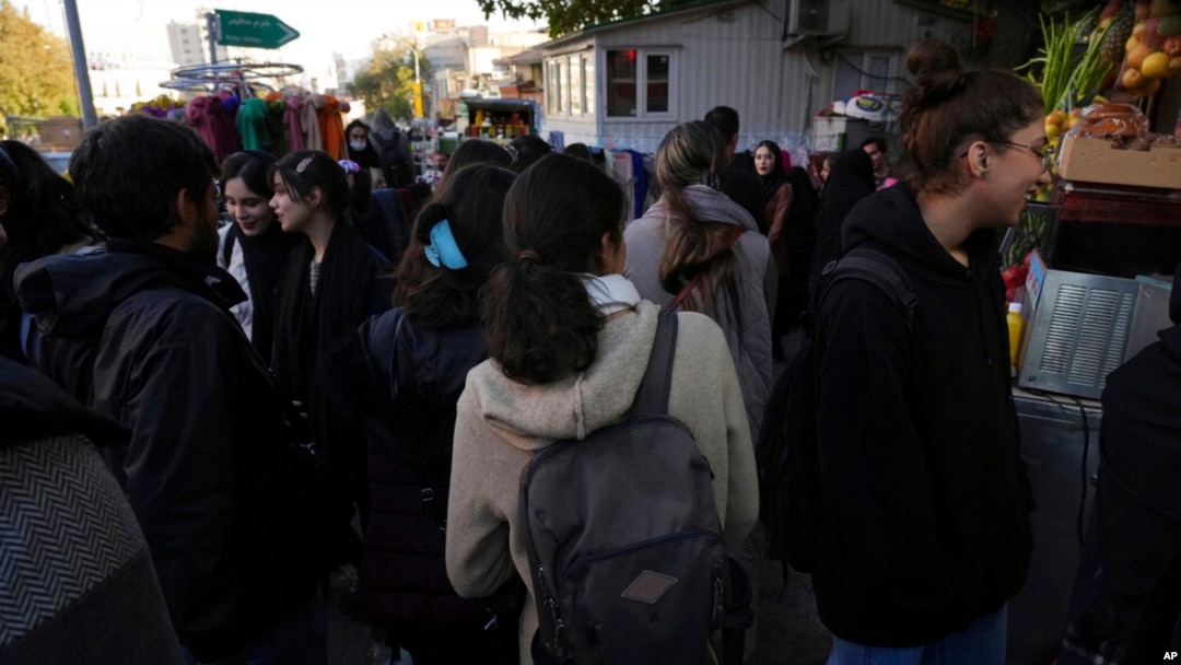 FILE - Iranian women walk in a commercial district without wearing their mandatory Islamic headscarves in northern Tehran, Nov. 14, 2022.