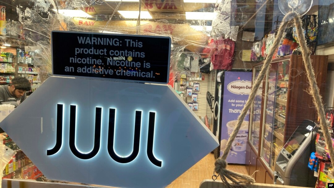 FILE - A Juul electronic cigarette sign hangs in the front window of a bodega convenience store in New York City on June 25, 2022. 