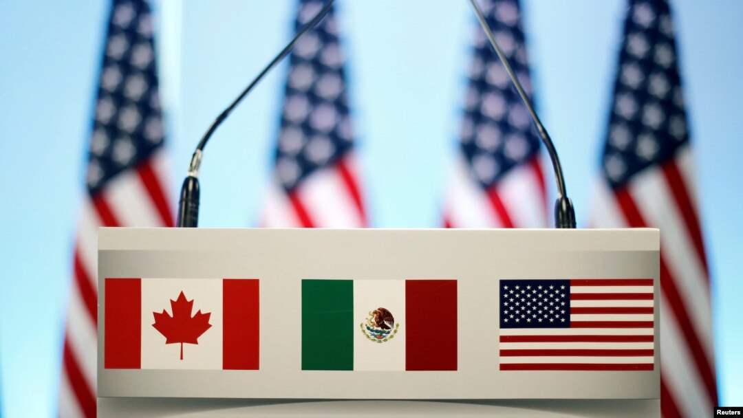 FILE - The flags of Canada, Mexico and the U.S. are seen on a lectern before a joint news conference on the closing of the seventh round of NAFTA talks in Mexico City, Mexico, March 5, 2018. 
