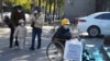 北京一家儿童医院外一名坐在轮椅上的男孩手拿医院影像科的片子。（2023年11月24日）