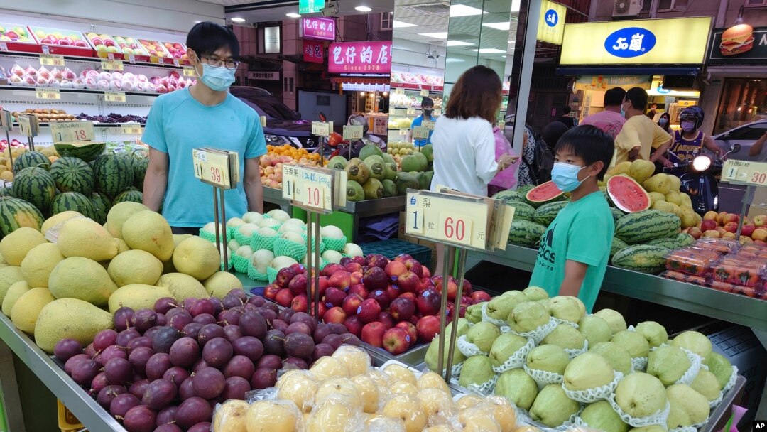 FILE - People buy fruit at a stall in Taipei, Taiwan, Sept. 20, 2021. 
