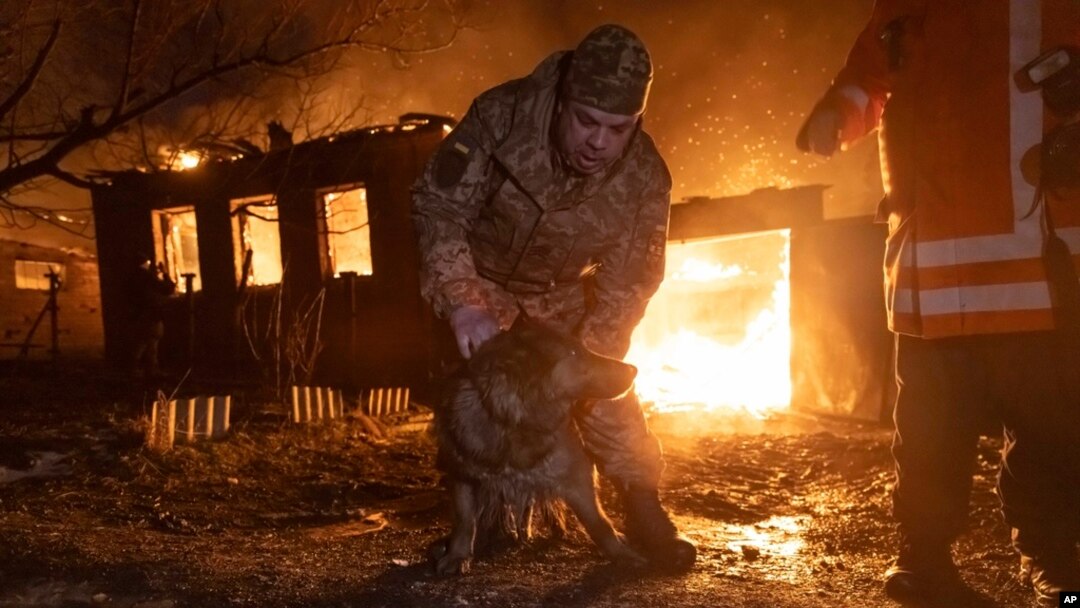 Firefighters rescue a dog as they extinguish a fire following a Russian attack on a residential neighborhood in Kharkiv, Ukraine, Feb. 10, 2024.