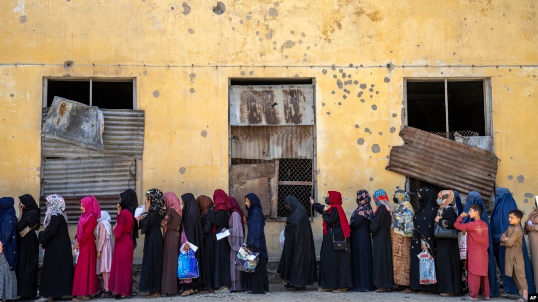 FILE - Afghan women wait to receive food rations distributed by a humanitarian aid group, in Kabul, Afghanistan, May 28, 2023.