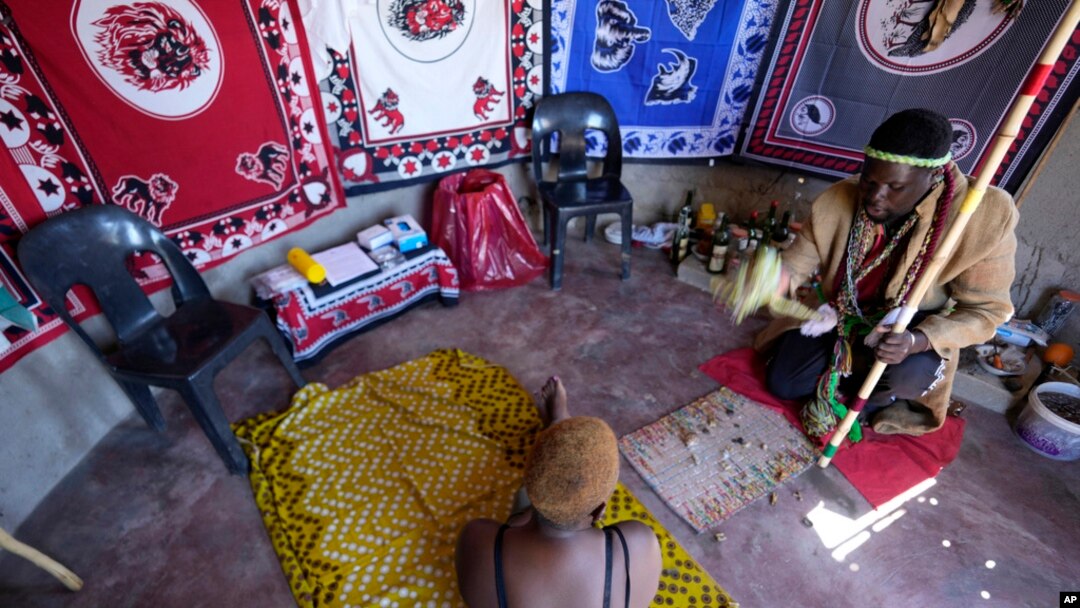 FILE - Traditional healer Shadrack Mashabane consults with his wife before testing her for HIV in Bushbuckridge, South Africa, May 9, 2024. 