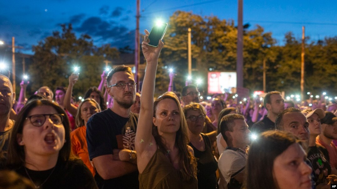 People use the lights on their mobile phones during a protest in Belgrade, Serbia, July 1, 2023.