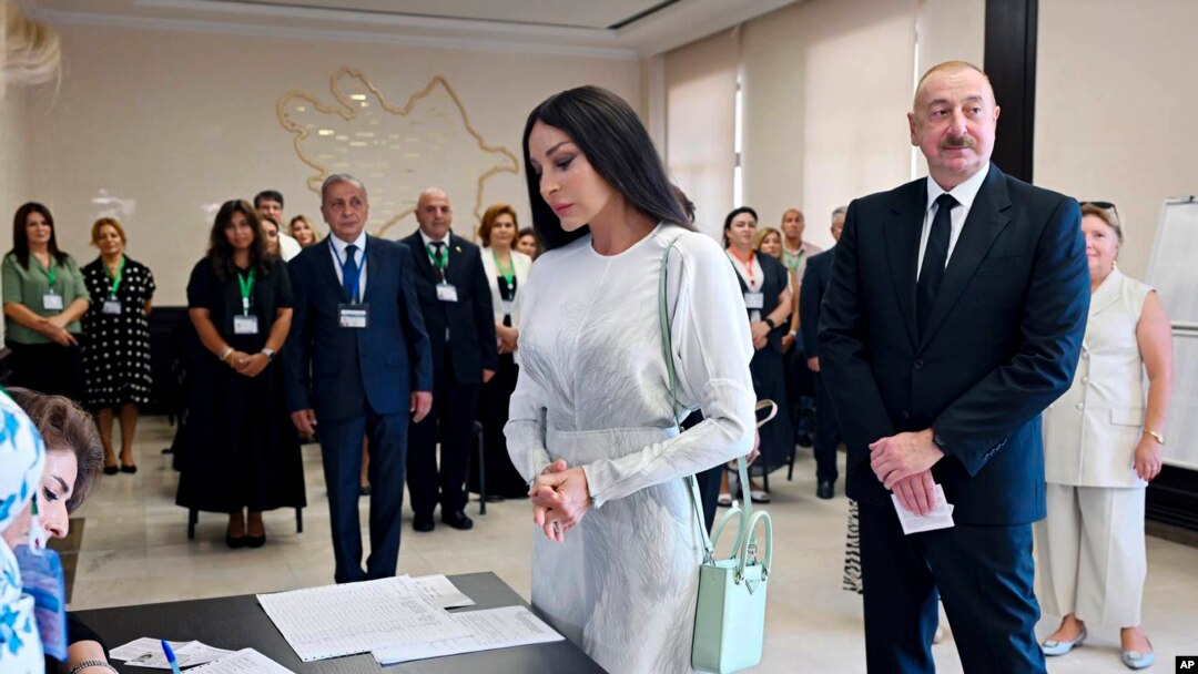 Azerbaijani President Ilham Aliyev, right, and his wife and Vice President Mehriban Aliyeva line up to collect their ballots at a polling station in Baku, Sept. 1, 2024. (Azerbaijani Presidential Press Office via AP)