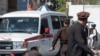 An ambulance carries victims from near the site of a suicide attack in Kabul on March 27, 2023. 
