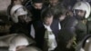 Police officers make way for former prime minister Imran Khan, center, upon his arrival at court, in Lahore, Pakistan, March 17, 2023. 