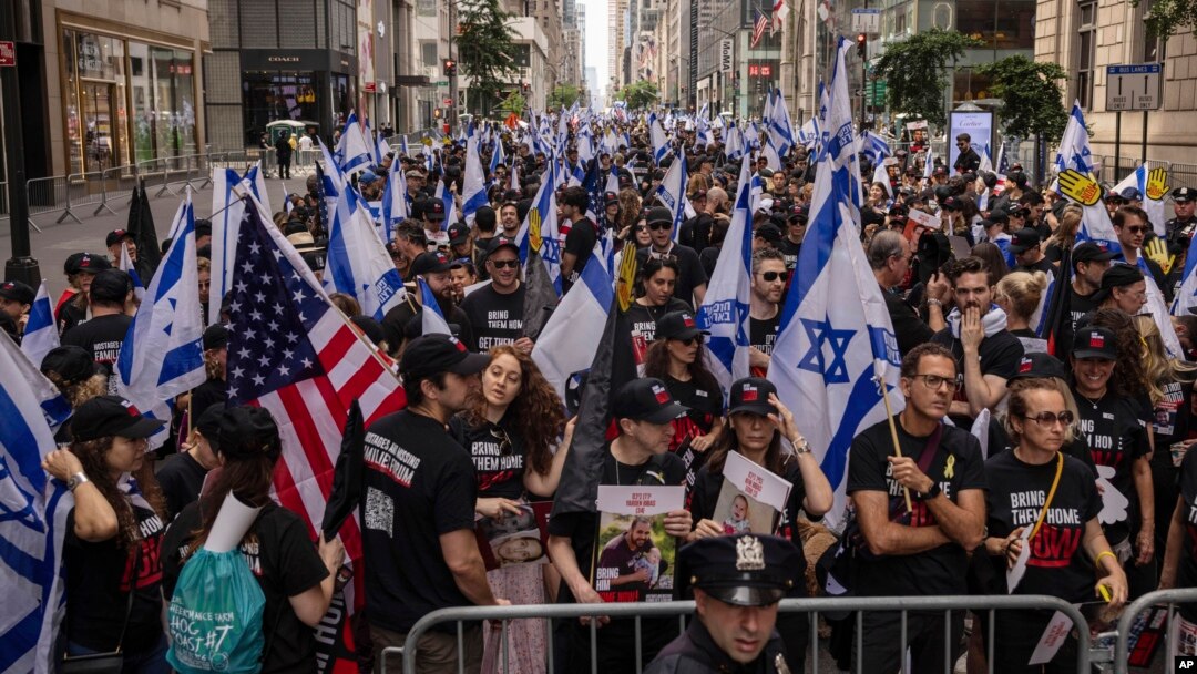 People hold Israeli flags, with one carrying a U.S. flag, as they gather ahead of the annual Israel Day Parade on Fifth Avenue in New York City, June 2, 2024.