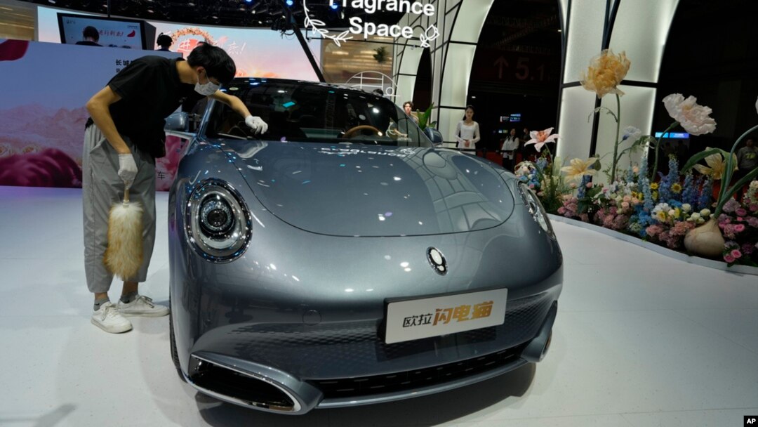 FILE - A worker wipes an Ora, a Chinese electric car, during the Auto Shanghai 2023 show at a convention center in Shanghai, April 18, 2023. The Biden administration will be increasing tariffs on certain imports from China, including EVs.