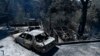 A charred vehicle and homes lie in ruins after a wildfire swept through the suburb of Nea Penteli in Athens, Aug. 13, 2024.