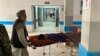 Men shift a wounded man inside a hospital in Mazar-i-Sharif on March 9, 2023, following a suicide attack at the office of the Taliban governor of Afghanistan's Balkh province. 