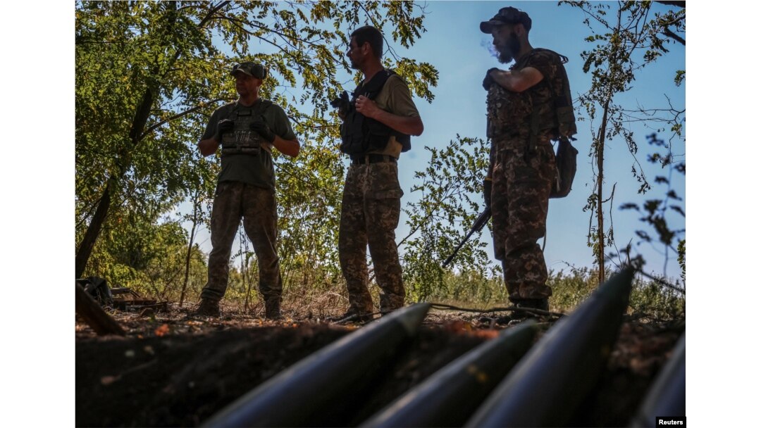 Ukrainian servicemen stand near artillery shells at a front line, amid Russia's attack on Ukraine, in Donetsk region, Ukraine, Sept. 22, 2023.