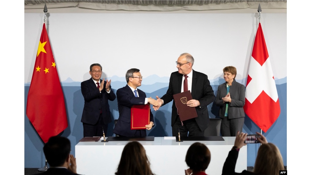 Swiss Economy Minister Guy Parmelin and Wang Shouwen, Chinese Vice Minister of the Ministry of Commerce, shake hands after signing a joint statement of the free trade agreement, in Kehrsatz, near Switzerland's administrative capital Bern, Jan. 15, 2024.