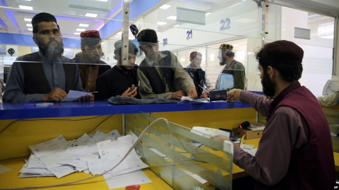 Afghan men wait to receive their passports from the main post office in Kabul, Afghanistan, July 3, 2024. 