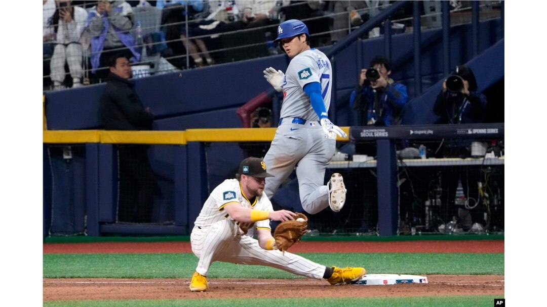 Los Angeles Dodgers designated hitter Shohei Ohtani, top, is forced out at first by San Diego Padres first baseman Jake Cronenworth during the seventh inning of an opening day baseball game at the Gocheok Sky Dome in Seoul, South Korea, March 20, 2024.
