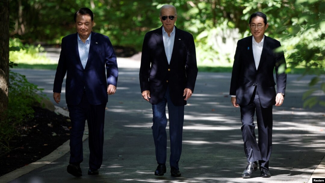 지난해 8월 메릴랜드주에 미국 대통령 별장 캠프 데이비드에서 조 바이든 미국 대통령과 윤석열 한국 대통령, 기시다 후미오 일본 총리가 공동회견을 위해 걸어들어오고 있다.