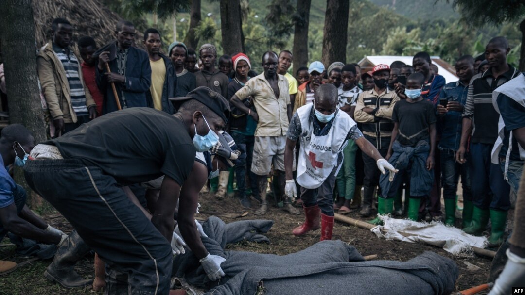 Congolese Red Cross volunteers and residents of Nyamukubi wrap in blankets the bodies of people who died in heavy flooding in eastern Democratic Republic of Congo, May 6, 2023. 