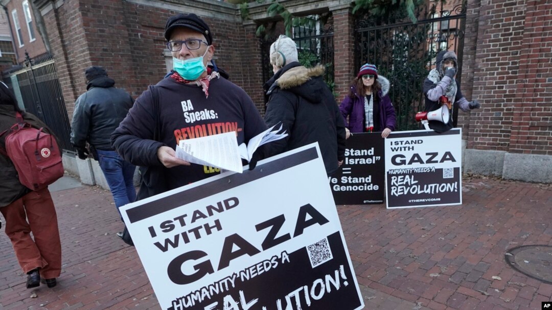 FILE - George Stevens of Cambridge, Mass., hands out leaflets to passers-by near an entrance to Harvard University, Dec. 12, 2023, in Cambridge, while joining with pro-Palestinian demonstrators during a protest held to call for an end to the war in Gaza.