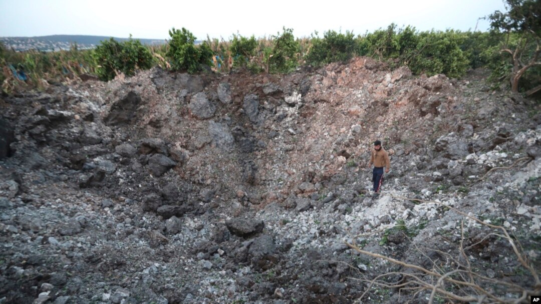 A Lebanese villager checks a huge crater that was made by an Israeli airstrike, in Qalili village, south Lebanon, April 7, 2023.