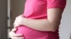 FILE - A pregnant woman stands for a portrait in Dallas, Texas, May 18, 2023. A Chinese woman's account of how she was lured into China's illegal surrogacy industry before suffering a miscarriage went viral on Chinese social media this week.