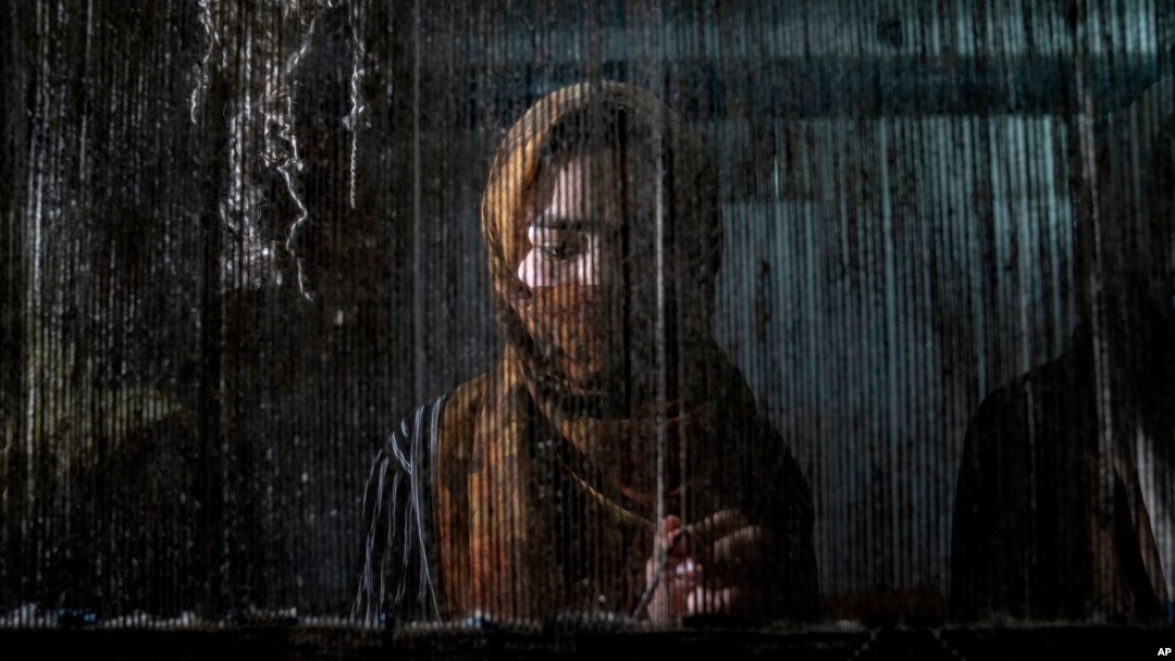 A woman weaves a traditional Afghan carpet at a factory in Kabul, Afghanistan, March 6, 2023.