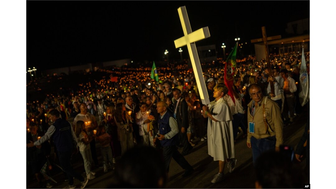 A youngster carries a cross during a Rosary and Candle procession at the Our Lady of Fatima shrine, in Fatima, Portugal, Aug. 4, 2023. Pope Francis is in Portugal through the weekend to preside over World Youth Day, a six-day jamboree.