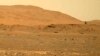 FILE - This April 30, 2021, image taken by the Mars Perseverance rover shows the Ingenuity helicopter, right, flying over the surface. Data gathered from the planet indicate there could be quite a bit of water well below the surface. (NASA via AP)