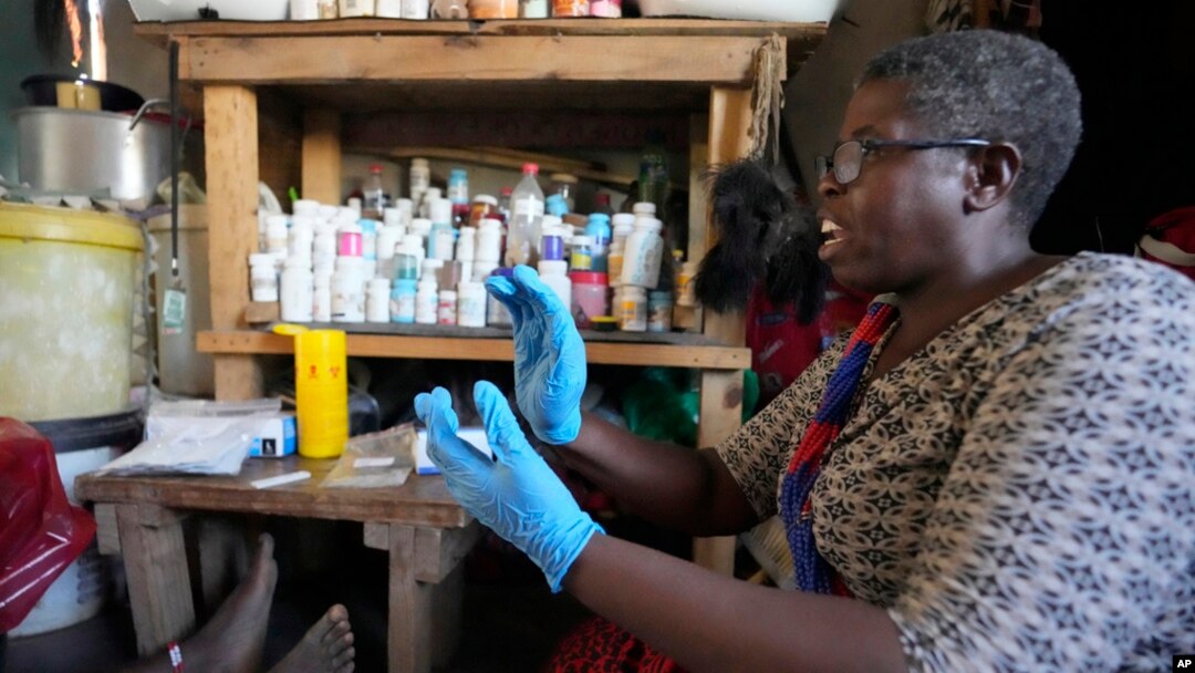 FILE - Traditional healer Florence Khoza talks to a patient before conducting a rapid HIV blood test in Bushbuckridge, South Africa, May 9, 2024.