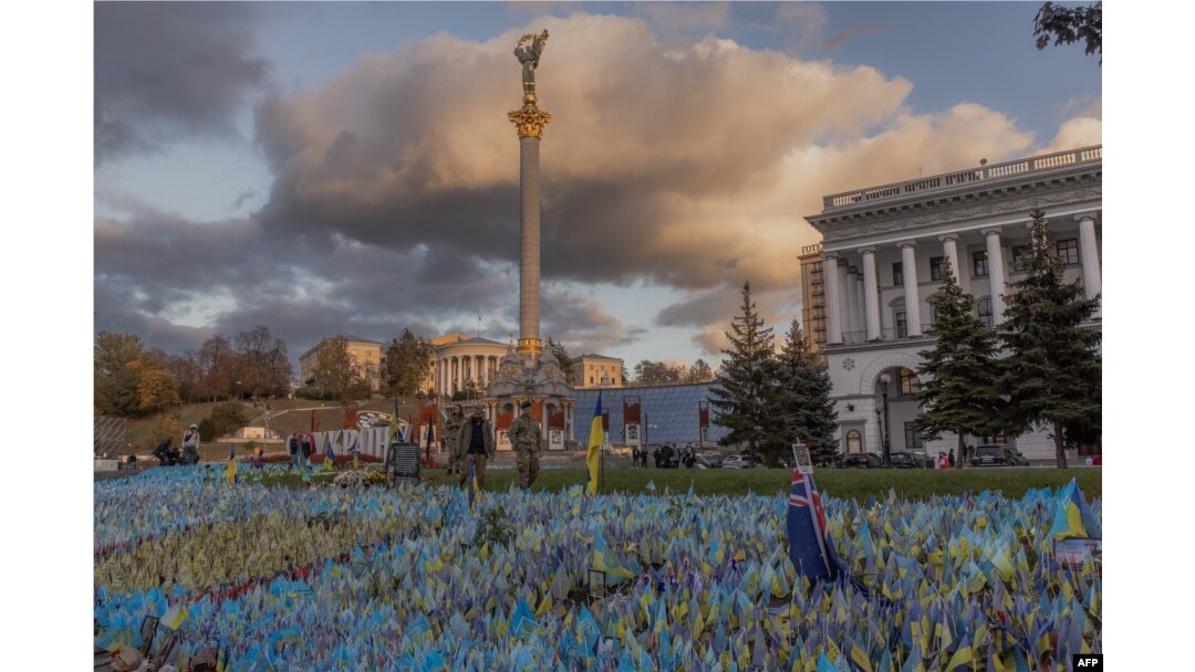 Pedestrians wearing military uniforms walk past flags bearing symbols and colors of Ukraine that commemorate the country's fallen soldiers at Independence Square in Kyiv, on Oct. 23, 2023, amid the Russian invasion of Ukraine.