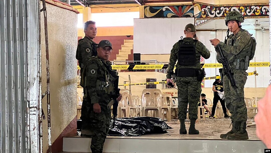 Military personnel stand guard at the entrance of a gymnasium while police investigators look for evidence after a bomb attack at Mindanao State University in Marawi, Lanao del sur province, Philippines, Dec. 3, 2023. 