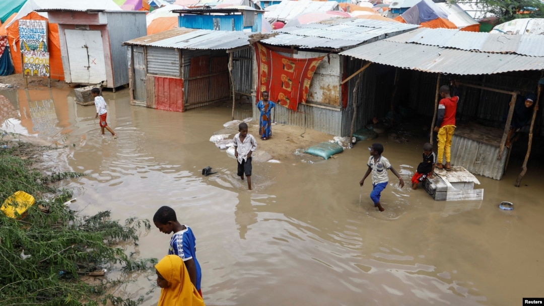 Somali children wade through floodwaters outside their makeshift shelters following heavy rains at the Al Hidaya camp for the internally displaced people on the outskirts of Mogadishu, Somalia, Nov. 6, 2023