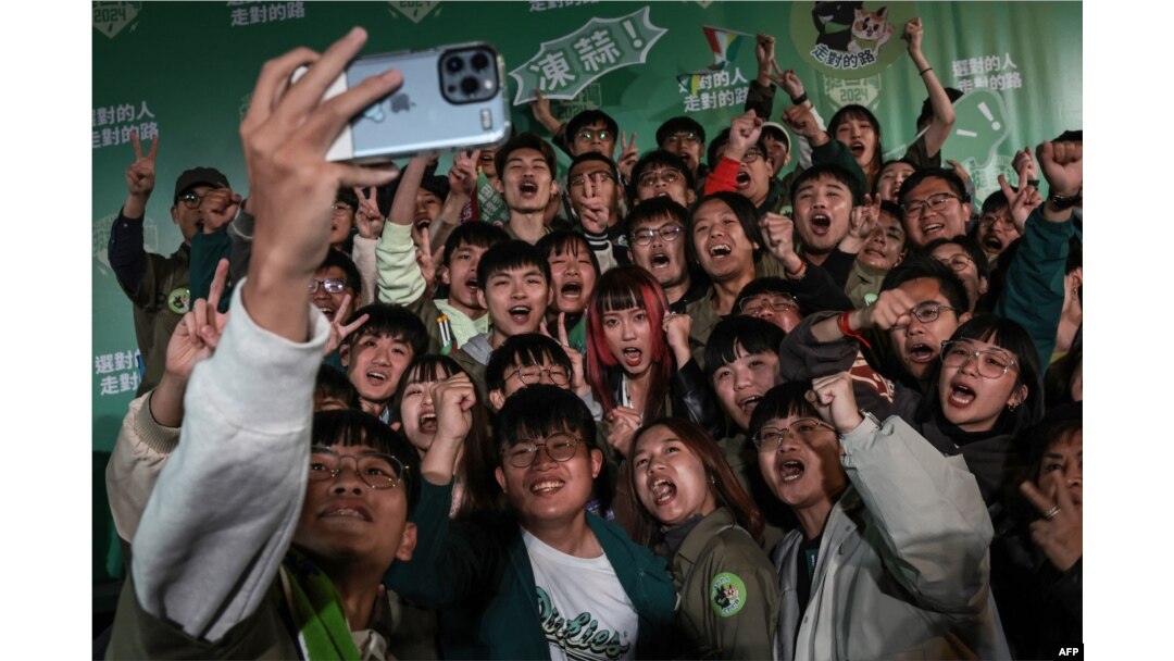 Supporters of Taiwanese Vice President and ruling Democratic Progressive Party presidential candidate Lai Ching-te pose for a group selfie in Taipei, Taiwan, after Lai won the presidential election, Jan. 13, 2024.