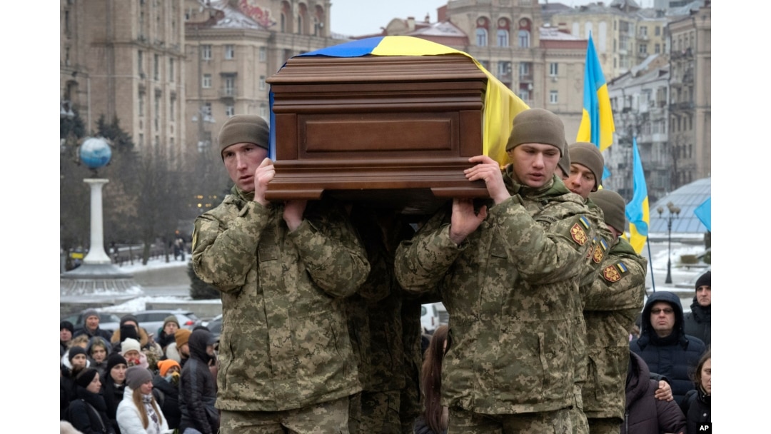 Ukrainian serviceman carry a coffin bearing Ukrainian poet Maksym Kryvtsov at St. Michael Cathedral in Kyiv, Ukraine, Jan. 11, 2024.