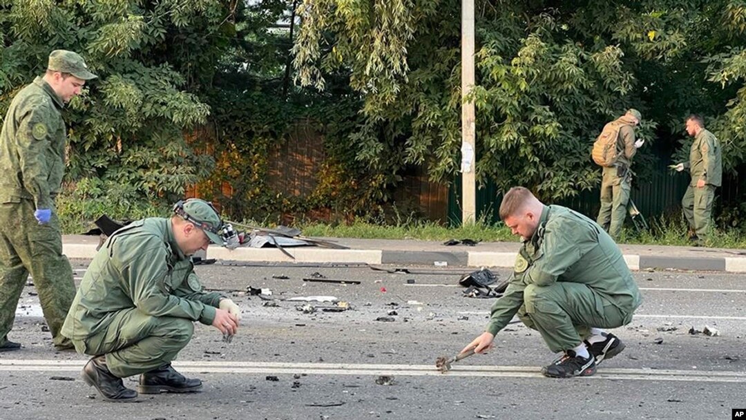 In this handout photo taken from video released by Investigative Committee of Russia on Aug. 21, 2022, investigators work on the site of explosion of a car driven by Putin Ally’s Daughter Daria Dugina outside Moscow. 