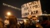 FILE - A high school student holds up a banner protesting dangerous levels of air pollution, in front of the government building in Skopje, North Macedonia, Dec. 20, 2019.