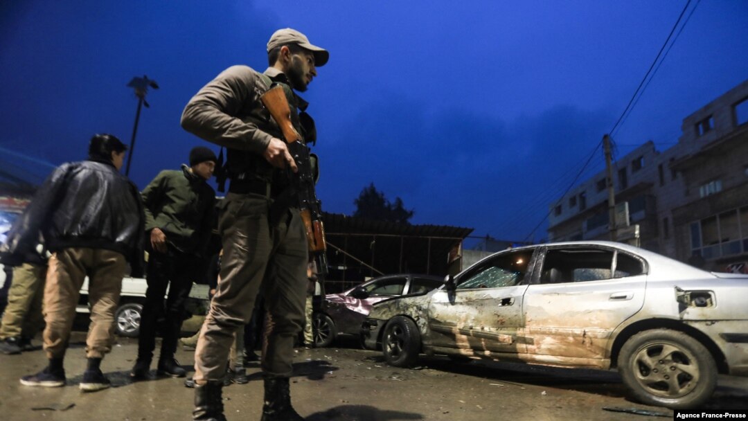 A Syrian fighter stands guard at the scene of an explosion that took place at the popular market of the Turkish-controlled city of al-Bab in Syria's northern Aleppo province on the border with Turkey, Jan. 13, 2022.