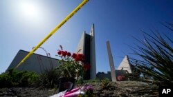 Flowers sit outside crime scene tape at Geneva Presbyterian Church on May 17, 2022, in Laguna Woods, Calif. A shooting at the church on Sunday left one dead and five injured.