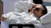 Egyptian medics and army personnel escort former Egyptian President Hosni Mubarak from a helicopter ambulance after it landed at Maadi Military Hospital following a hearing in his retrial in Cairo, Apri. 13, 2013. 