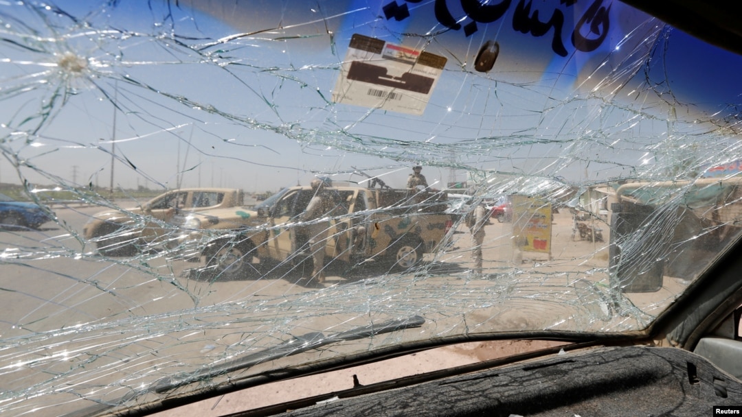 An Iraqi security vehicle is pictured through a shattered windshield of a vehicle damaged at the site of car bomb attack in Rashidiya a district north of Baghdad, Iraq, July 12, 2016.
