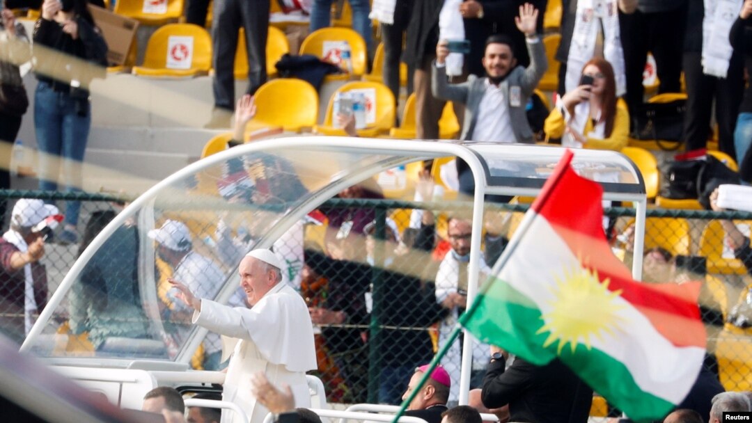 A Kurdistan flag is held up as Pope Francis arrives to hold a mass at Franso Hariri Stadium in Erbil, Iraq, March 7, 2021. 
