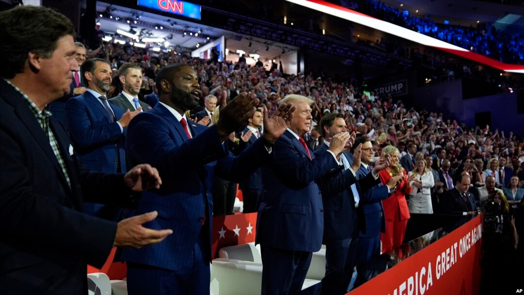 Republican presidential candidate former President Donald Trump and Republican vice presidential candidate Senator JD Vance, attend the first day of the Republican National Convention, July 15, 2024, in Milwaukee. At left is Tucker Carlson and Representative Byron Donalds.