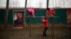 Students play next to a portrait of Soviet leader Joseph Stalin at the Democracy Elementary and Middle School in Sitong town, Henan province, China, Dec. 3, 2013.