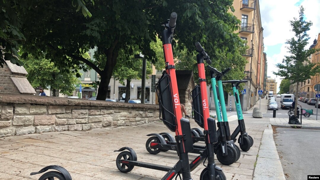 Electric scooters from Swedish startup VOI and Belin-based Tier sit parked side-by-side in Stockholm, Sweden, July 7, 2019. 