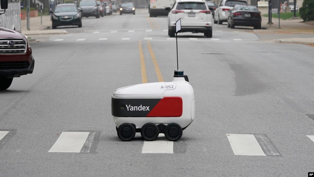 A food delivery robot crosses a street in Ann Arbor, Mich. on Thursday, Oct. 7, 2021. (AP Photo/Carlos Osorio)