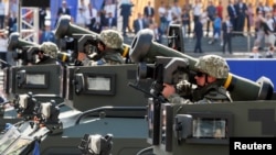 FILE - Ukrainian soldiers ride with Javelin anti-tank missiles during a military parade marking Ukraine's Independence Day, in Kyiv, Aug. 24, 2018. 