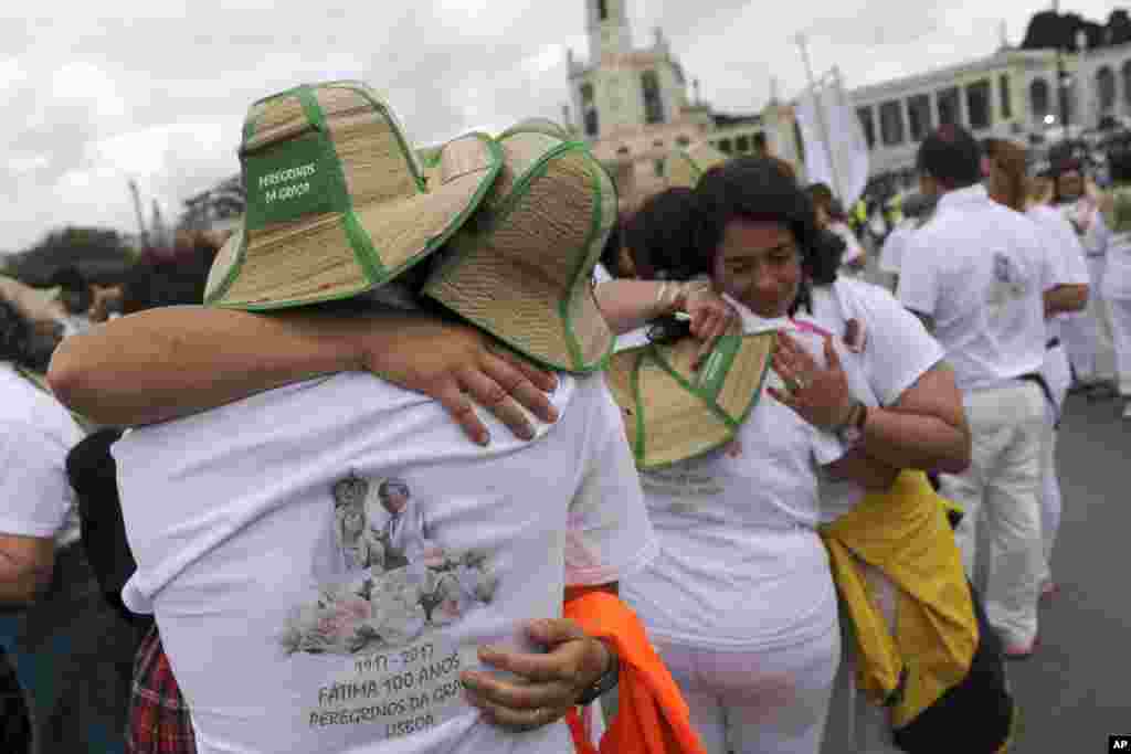 A group of pilgrims from Lisbon embrace after their arrival at the Sanctuary of Our Lady of Fatima, in Fatima, Portugal. On Saturday Pope Francis will canonize two poor, illiterate shepherd children whose visions of the Virgin Mary 100 years ago marked one of the most important events of the 20th-century Catholic Church. 