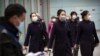 Flight crew members wearing face masks walk through the international arrivals area at Beijing Capital International Airport in Beijing, Thursday, Jan. 30, 2020. China counted 170 deaths from a new virus Thursday and more countries reported…