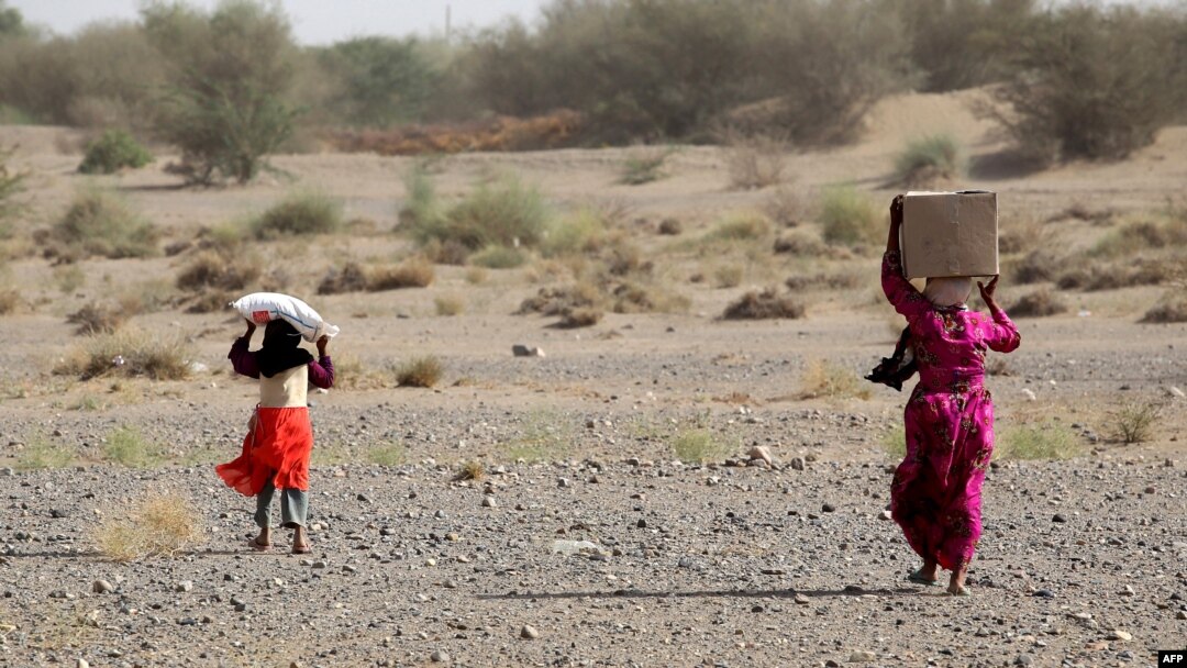 FILE - Yemenis displaced by conflict receive food aid and provisions to meet their basic needs at a camp in the Khokha district of Yemen's war-ravaged western province of Hodeida, Jan. 31, 2022. 