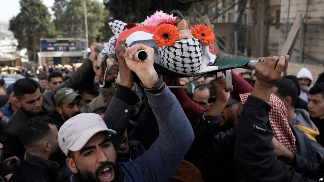 Palestinian mourners carry the body of Ahmad Kahla, 45, during his funeral in the West Bank village of Rammun, Jan. 15, 2023. The Palestinian Health Ministry says Israeli troops have shot and killed the Palestinian man in the occupied West Bank.